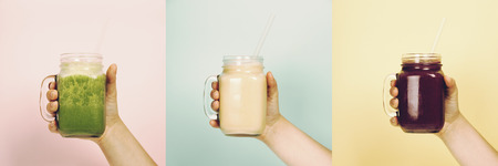 Woman (teenage girl) hand holding smoothie shake against bright wall - collageの写真素材