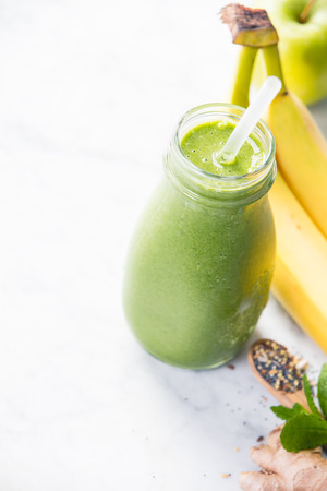 Close-up of green fresh smoothie with fruits, berries, oats and seeds, selective focus. Detox, dieting, clean eating, vegetarian, vegan, fitness, healthy lifestyle conceptの写真素材