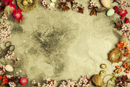 Easter composition: branch with cherry blooming flowers and easter decorations on aged stone backgroundの写真素材