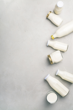 Various bottles of milk on grey concrete backgroundの写真素材