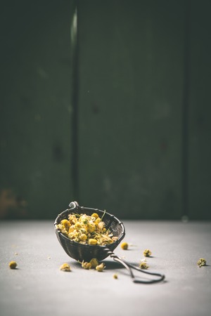 chamomile tea in strainer on vintage backgroundの写真素材