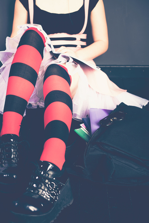 Young alternative girl with school bag on the wooden floorの写真素材