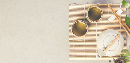 Asian food background - tea and chopsticks on a grey concrete background. Top view, flat layの写真素材