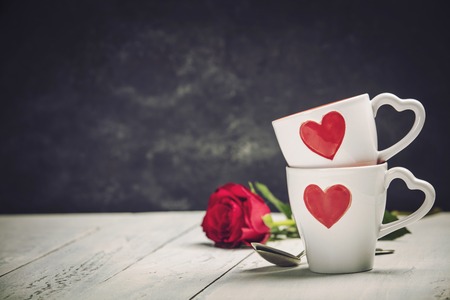 Valentine's Day concept. Red Cups and roses on a Woodenの写真素材