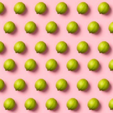 Limes pattern on pink background. Creative food concept. Flat lay composition for bloggers, magazines, web designers, social media and artists.の写真素材