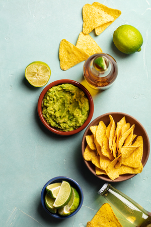 Nachos, guacamole and beer on blue background, flat layの写真素材