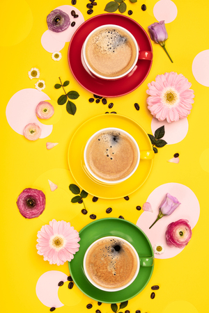 Cups of Coffee and colorful paper circles on yellow paper background, flat layの写真素材