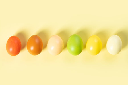 Painted traditional eggs for Easter holiday over light yellow