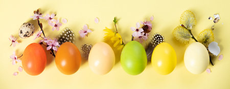 Painted traditional eggs for Easter holiday, spring flowers and feathers