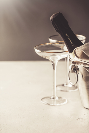 Champagne bottle in bucket and glasses on concrete background, copyspaceの写真素材