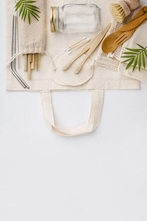 Natural color eco bags, reusable metal and bamboo straws, glass jars, wooden knifes and forks, zero waste cleaning and beauty products, flat layの写真素材