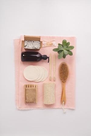 Zero waste, Recycling, Sustainable lifestyle concept. Eco-friendly bathroom accessories: toothbrushes, reusable cotton make up removal pads, make up remover in a glass container, natural brush, bamboo ear sticks, olive oil soap. Flat layの写真素材
