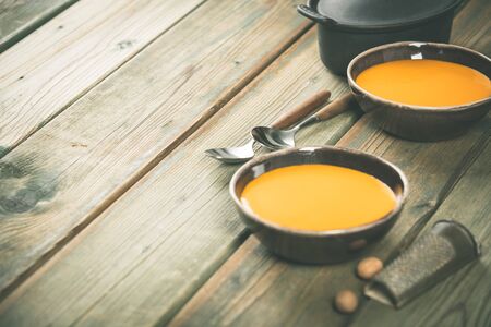 Pumpkin soup on wooden table, space for textの写真素材
