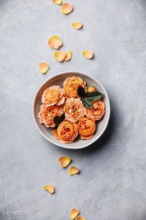Orange roses floating in water on concrete background, SPA and relaxation conceptの写真素材