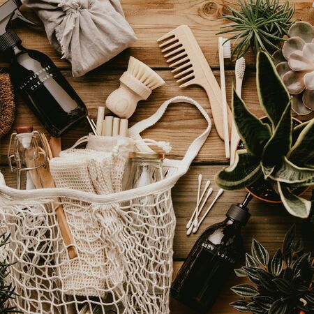 Collection of various succulent plants and Mesh market bag with bamboo cutlery, reusable bottles, eco cotton bags, house cleaners and bathroom accessories on wooden background. Sustainable lifestyle. Plastic free concept.の写真素材