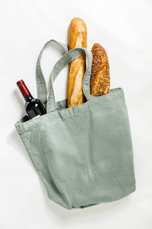 Fresh baguette and bottle of wine in cotton bag.の写真素材