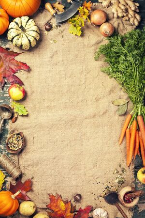 Healthy food cooking background. Vegetable ingredients. Fresh garden carrots, onions, pumpkins, ginger and spices on rustic wooden background, top view, copy spaceの写真素材