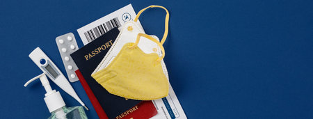 Coronavirus and travel concept. Passports, airplane tickets, sanitizer, thermometer and medical mask...