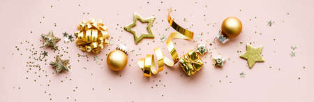 Flat lay of Celebration. Golden Christmas decorations on pink backgroundの写真素材