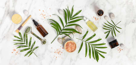 Natural SPA cosmetic products background, Composition with bottles of essential oils, sea salt and massage rollers on white marble backgroundの写真素材