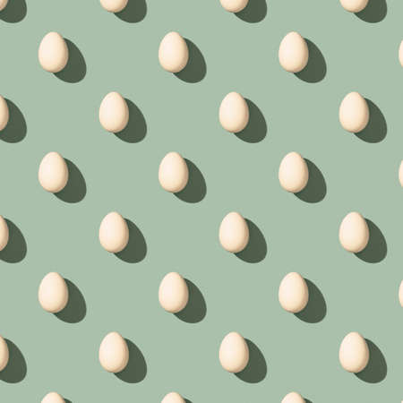 Pattern made of white eggs on pastel green background. Minimal food concept. Flat layの写真素材