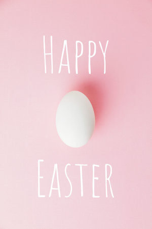 White Easter egg on pastel pink background. Happy Easter concept.