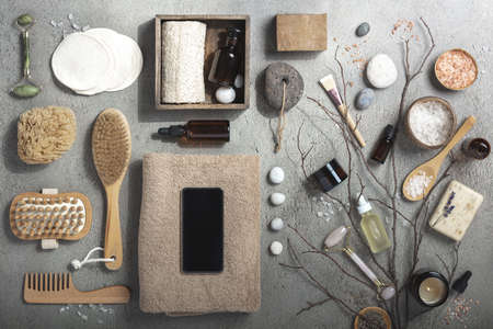 Mock up with organic cosmetic products, eco friendly natural ingredients and mobile phone on grey background, flat layの写真素材