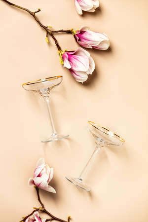 Spring magnolia flowers and wine glasses flat lay, top viewの写真素材
