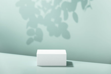 Abstract empty white podium with eucalyptus leaves on blue backgroundの写真素材