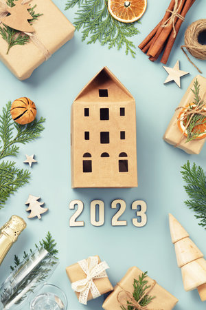 Natural color Christmas gift boxes, decorations and Champagne on blue background flat lay