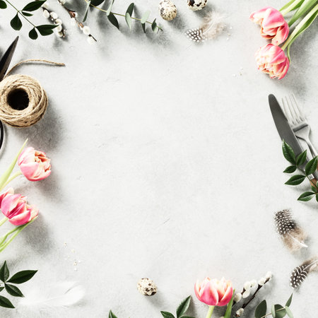 Easter background with spring flowers and cutlery on light grey background top view flat lay