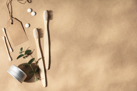 Two natural wooden toothbrushes on natural beige background with leaves shadows, flat lay, top viewの写真素材