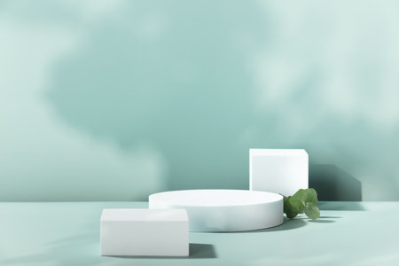 Empty cosmetics podiums on blue background with shadow and leaves for productの写真素材
