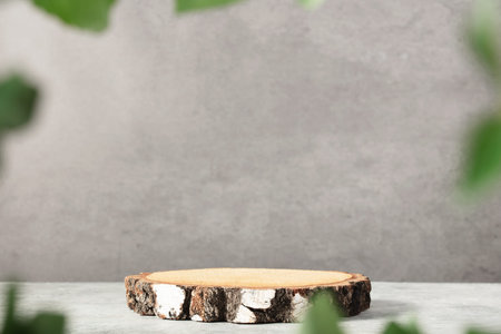 Wooden product display podium with blurred nature leaves background. 3D rendering