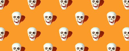 Halloween decorations. Human skull pattern with the orange backgroundの写真素材