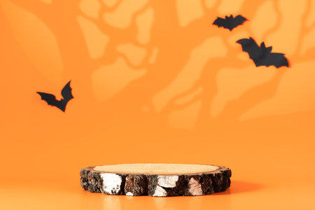 Creative Halloween composition with paper bats, podium and orange background. Modern Halloween aesthetic.の写真素材