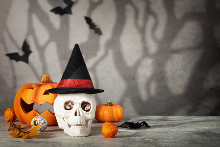 Halloween holiday concept with skull wearing witch hat. Minimal surreal creative concept for Halloween celebration banner or advertisement. Halloween background, copy spaceの写真素材