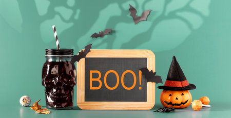 Happy halloween holiday concept. Halloween decorations, bats, ghosts, spiders, pumpkins, skull, cup of Chocolate with marshmallow on blue background. Halloween party poster mockup with copy space.の写真素材