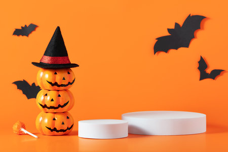 Creative Halloween composition with paper bats, podium and orange background. Suitable for Product Display and Business Concept.の写真素材