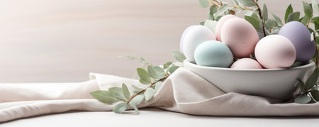 Composition with beautiful pastel colored Easter eggs, spring plant leaves and cloth on grey background bannerの素材