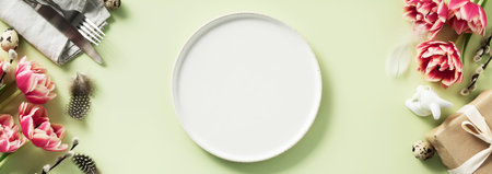 Easter table setting with white plate, spring flowers and cutlery. Holidays backgroundの写真素材
