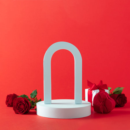 Abstract empty white podium with arch, hearts and rose flowers on red backgroundの写真素材