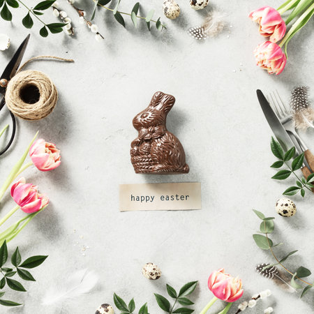 Easter Chocolate Bunny spring flowers and cutlery on light grey backgroundの写真素材