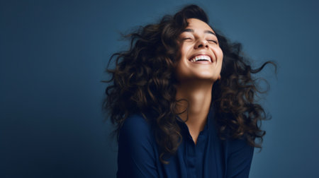 Portrait of an excited young woman celebrating success, yellow backgroundの素材