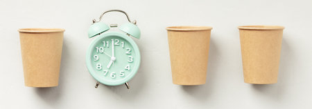 Alarm Clock Flanked by Paper Cups on Whiteの写真素材