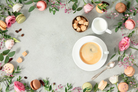White cup of coffee and Frame made of Spring flowers and different types of macaroonsの写真素材