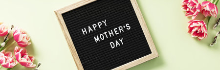 Spring season still life with pink tulips and Happy Mothers day text on letter board top viewの写真素材