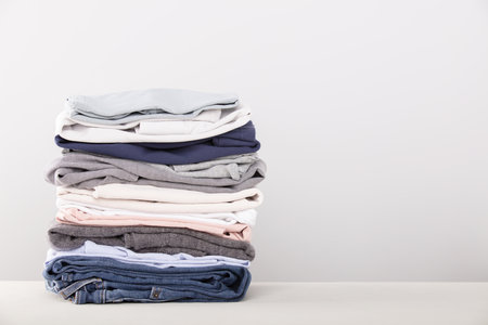 stack of folded clothes, grey backgroundの写真素材