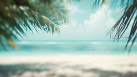 A softly blurred vision of a tropical beach, evoking the hazy warmth of a summer day by the sea with palm leaves in the foreground.の素材