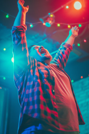Joyful Man Celebrating with Arms Raised in Neon Lights, body positivityの素材